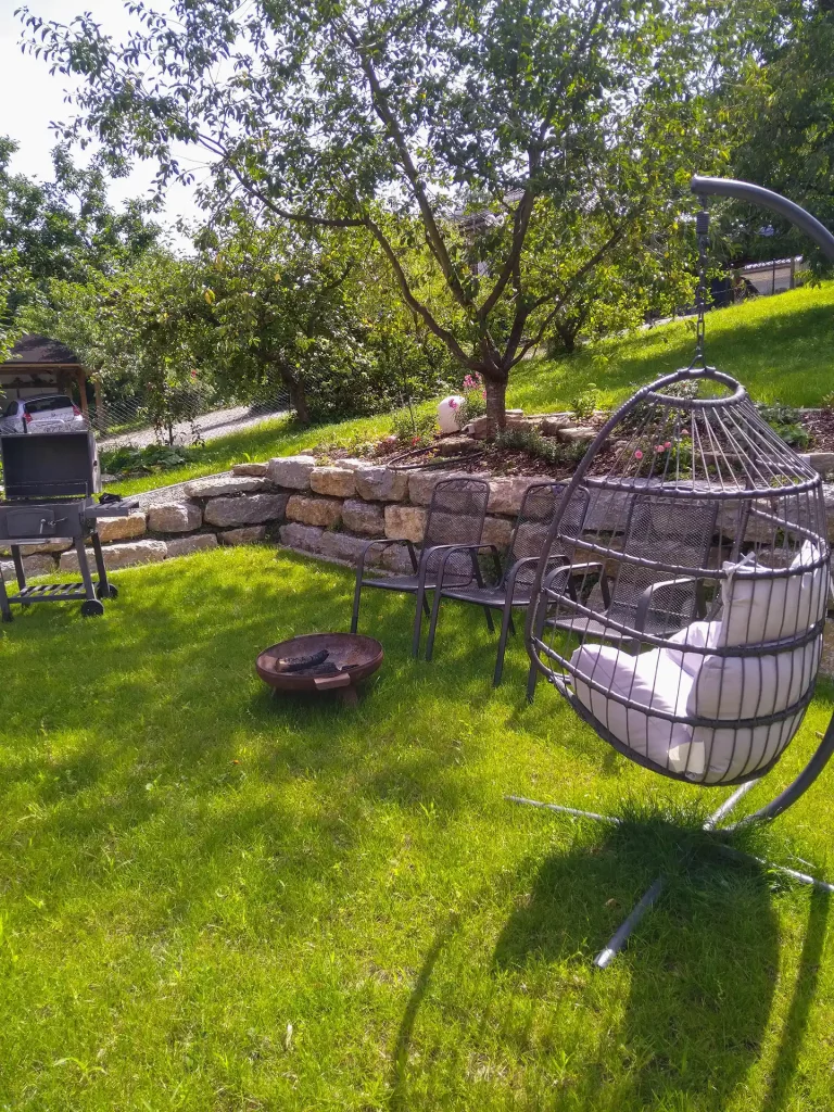 Gartengestaltung mit Natursteinmauer, Grillplatz und Sitzgelegenheit, erstellt von der Firma Aussengestaltung Vogt