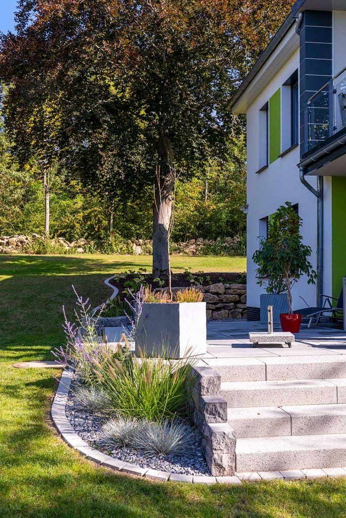 Gartenmauer mit Treppenanschluss im Eingangsbereich eines Hauses, erstellt von der Firma Aussengestaltung Vogt
