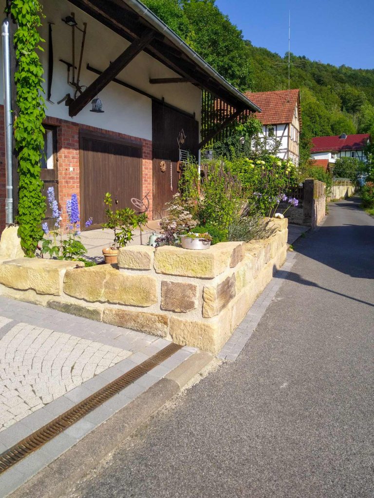 Gartenmauer und gepflasterte Garagenzufahrt, erstellt von der Firma Aussengestaltung Vogt