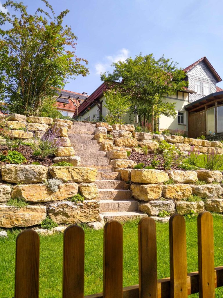 Gartengestaltung mit Mauern und Treppe, erstellt von der Firma Aussengestaltung Vogt