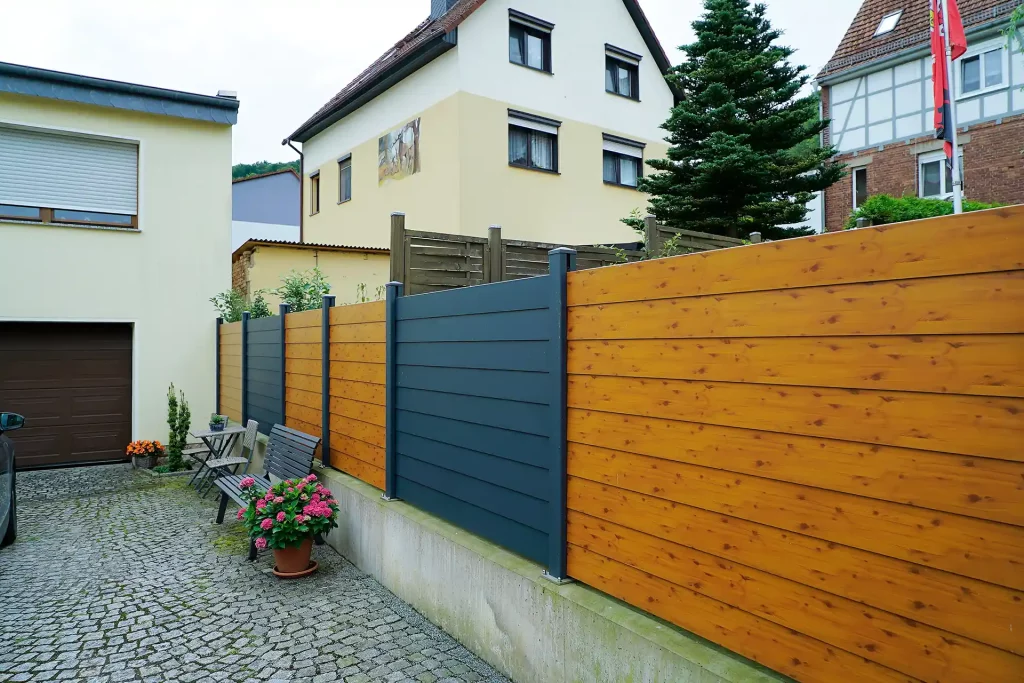 Zaun aus Holz- und Metallelementen, erstellt von der Firma Aussengestaltung Vogt