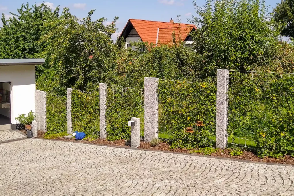 Gartenzaun und gepflasterte Auffahrt, erstellt von der Firma Aussengestaltung Vogt