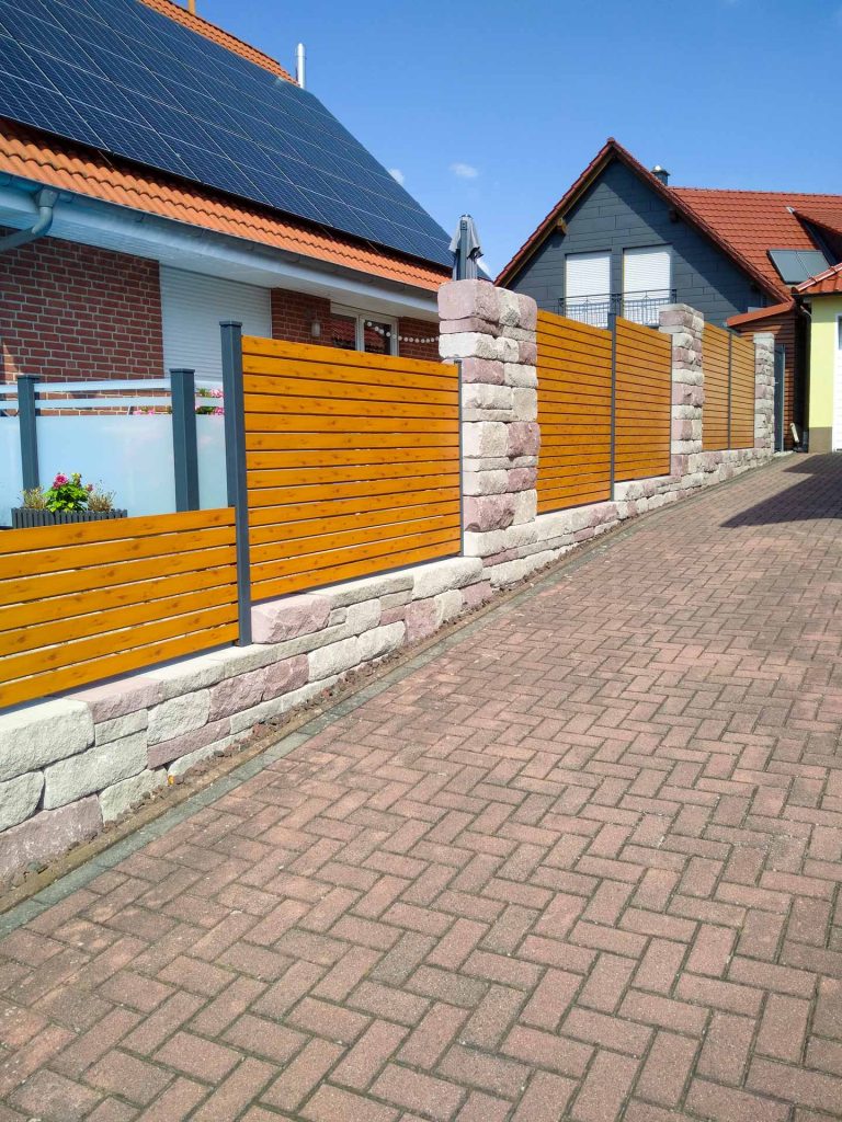 Zaun aus Holzelementen zur Abtrennung einer Garagenzufahrt, erstellt von der Firma