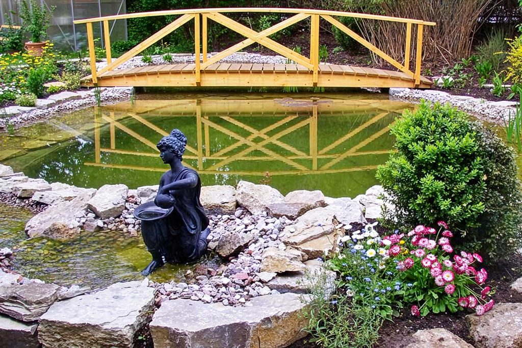 Gartenteich mit Brücke uns Statue, erstellt von der Firma Aussengestaltung Vogt